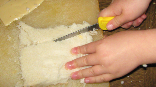 Children learning to use a knife.